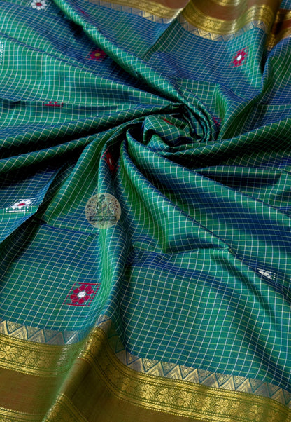 Close-up of Bishnupuri pure katan silk weave – natural mulberry silk lustre holding warm light, intricate handwoven Bengal motifs for bridal and cultural celebrations