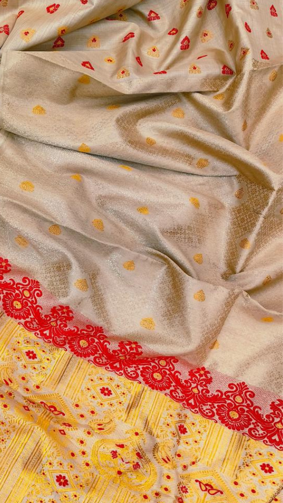 Woman draped in a golden Muga silk handloom saree, styled for a festive occasion — Dakshin Vastram UK