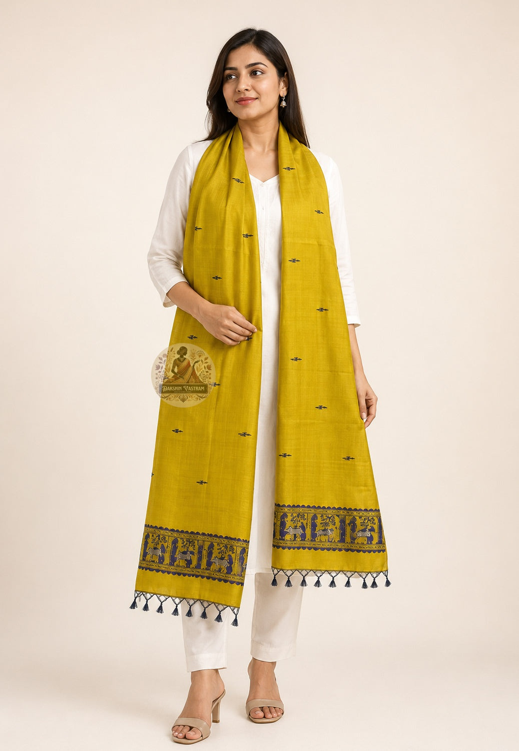 Front view of handwoven Baluchari silk stole in turmeric yellow – pure silk with indigo mythological border and black tassels, draped over white kurta – Dakshin Vastram