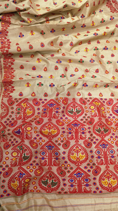Handwoven Muga silk saree from Sualkuchi's weaving families laid flat, showing deep golden body and intricately woven traditional border — Dakshin Vastram