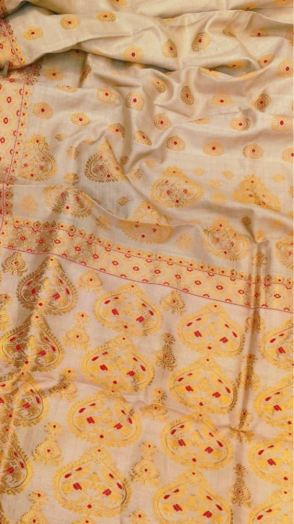 Close-up of handloom Muga silk saree showing Antheraea assamensis silk thread with natural golden colour of Assam's Brahmaputra valley, lustre that deepens with age and cannot be replicated elsewhere
