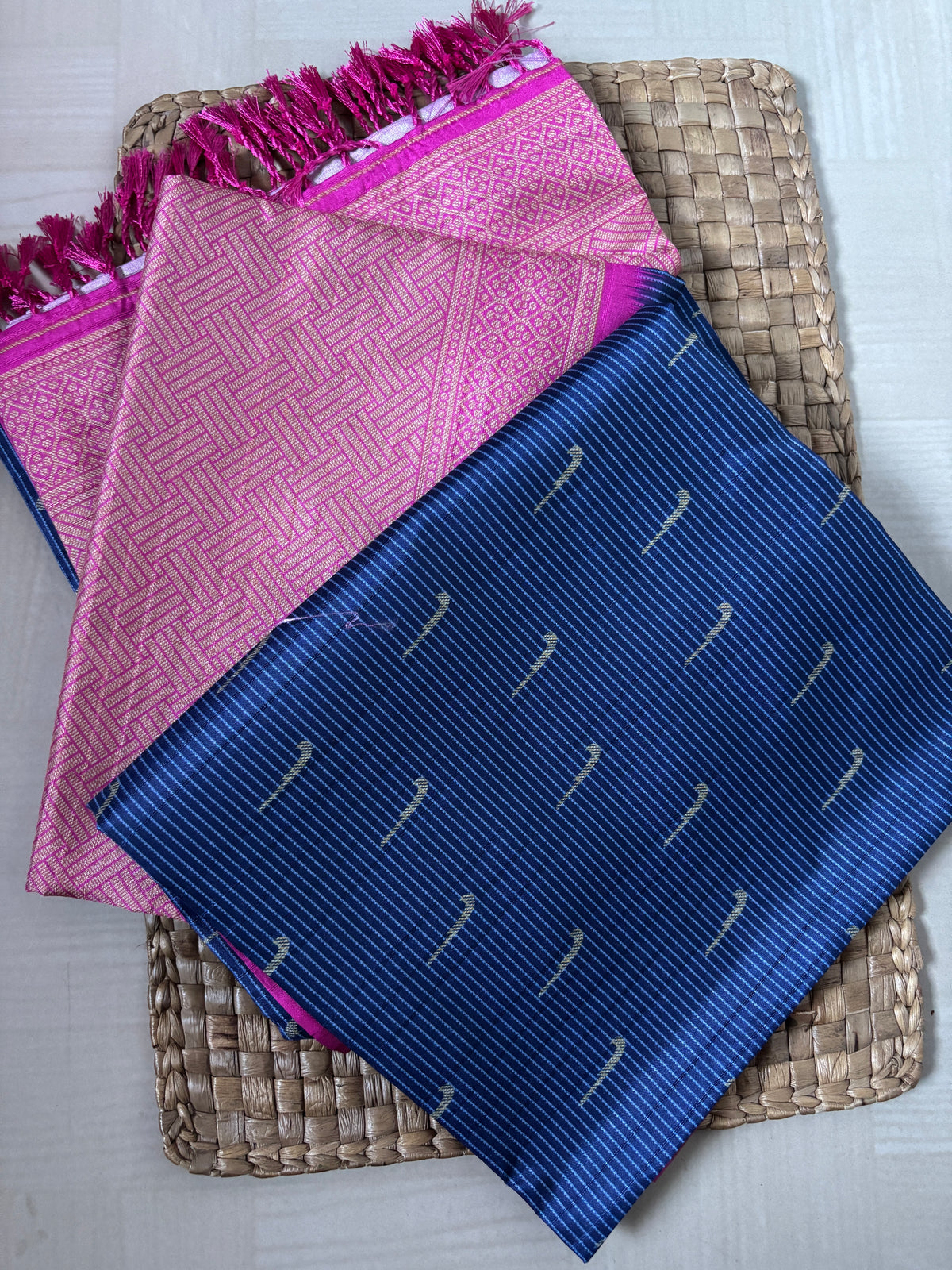Pink and blue patterned cloths on a woven mat